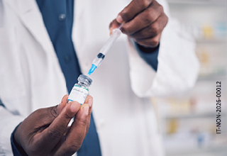 Vaccinare in farmacia: cosa c'è da sapere Farmacista prepara un vaccino in farmacia durante la campagna vaccinale